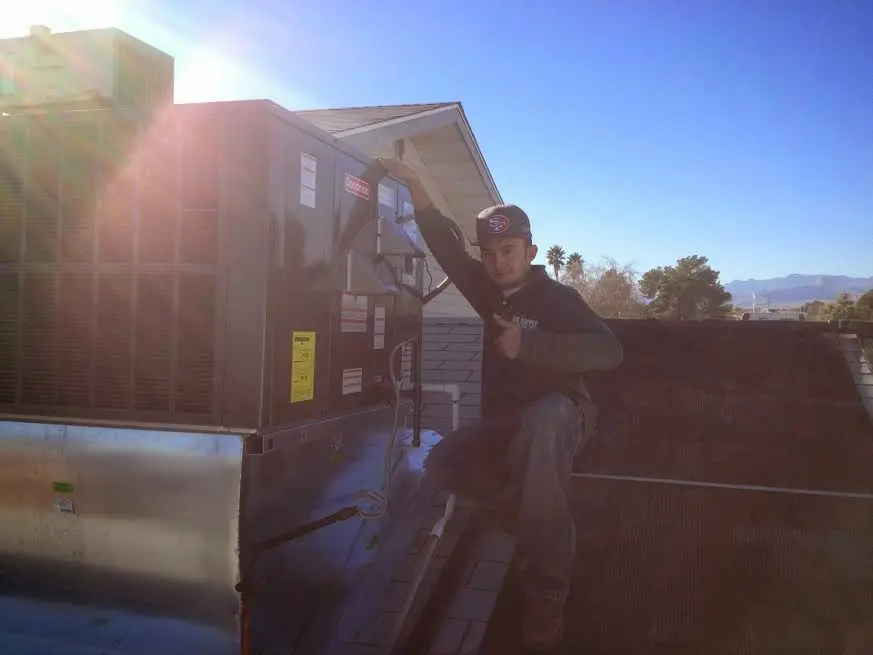 HVAC technician performing AC Tune-Up on a rooftop unit in Lynwood